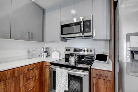 A modern kitchen with a stove top oven and microwave above it.