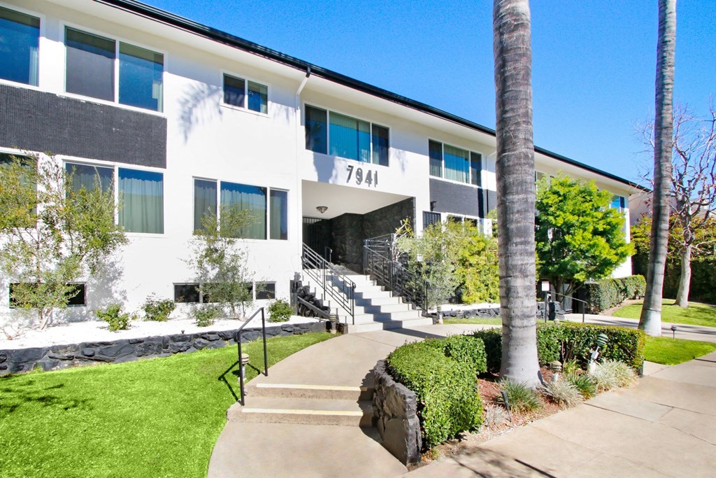 the front of a building with stairs and a sidewalk