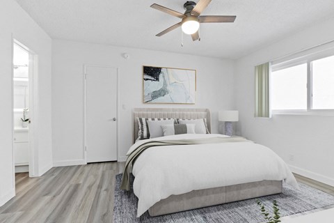 a bedroom with a large bed and a ceiling fan