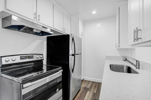 A modern kitchen with a stainless steel refrigerator and oven.