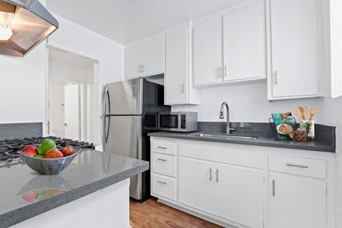 a kitchen with white cabinets and a stainless steel refrigerator
