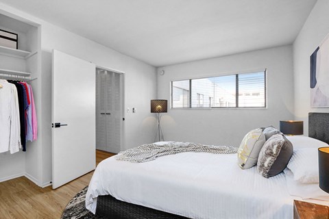 A bedroom with a bed, a wardrobe, and a window.