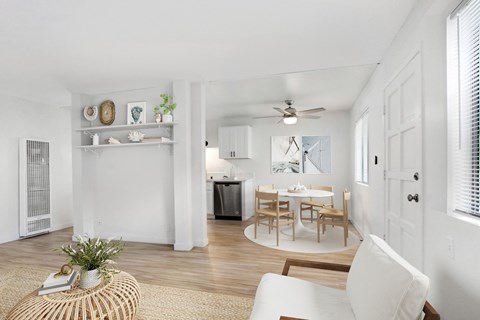 A white living room with a dining table and chairs.