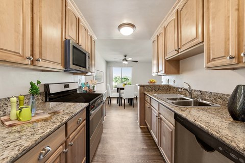 A kitchen with wooden cabinets and granite countertops.