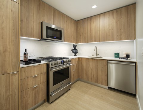 A modern kitchen with wooden cabinets and stainless steel appliances.