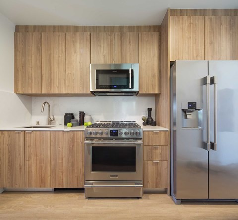 A modern kitchen with wooden cabinets and stainless steel appliances.