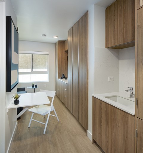 A modern kitchen with wooden cabinets and a white table.