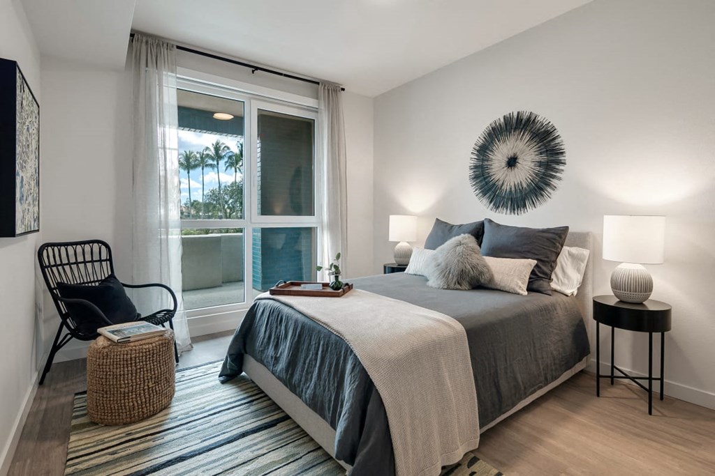 a bedroom with a bed and a large window