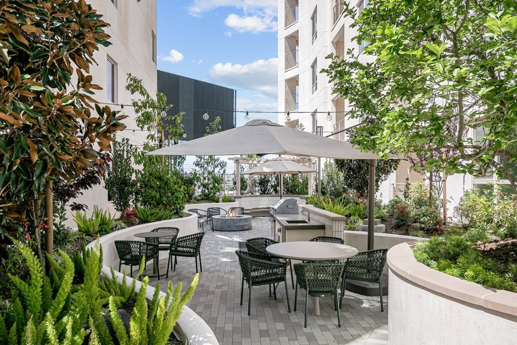 a patio with tables and chairs and an umbrella