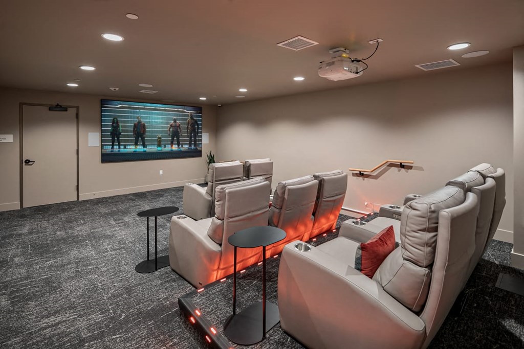 a theater room with couches and chairs