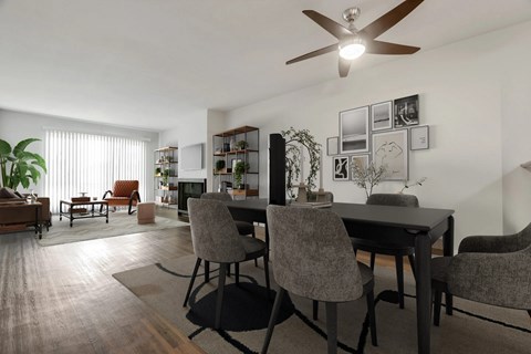 A modern dining room with a table set for four and a ceiling fan.