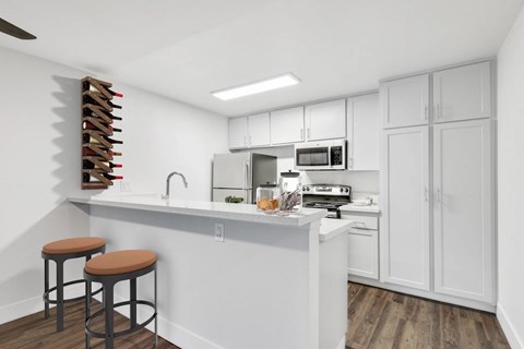 A kitchen with white cabinets and a white counter top.