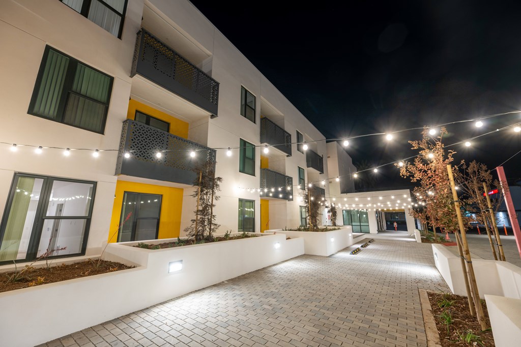 A building with yellow doors and windows is lit up at night.