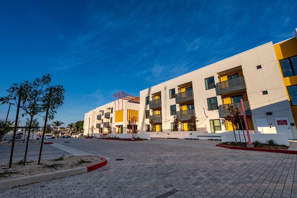 A modern building with yellow and white exterior and a red stripe on the roof.