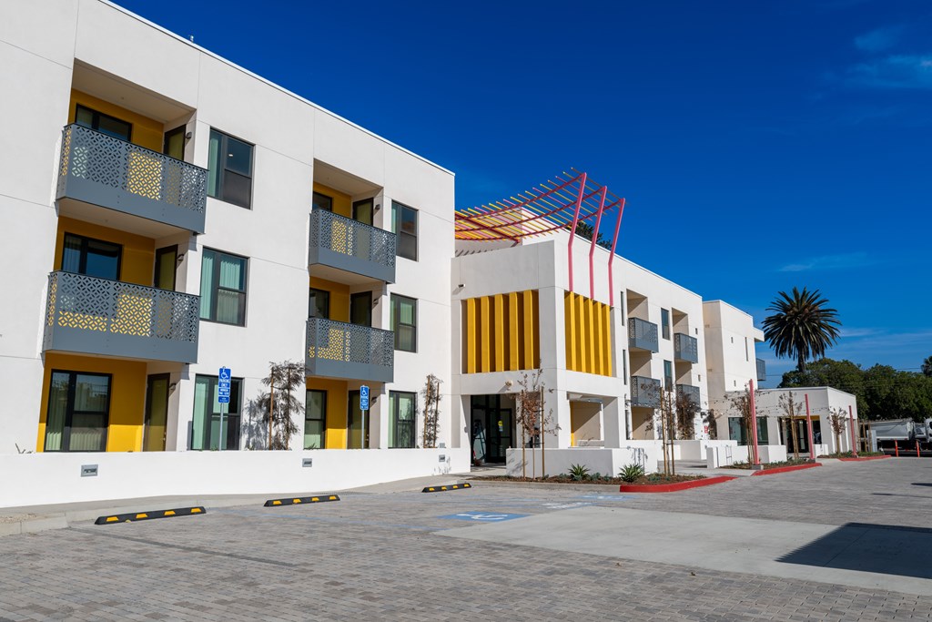 A white building with yellow and grey balconies.