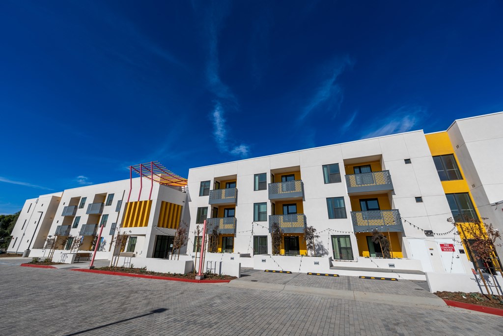 A modern building with white and yellow exterior and red accents.