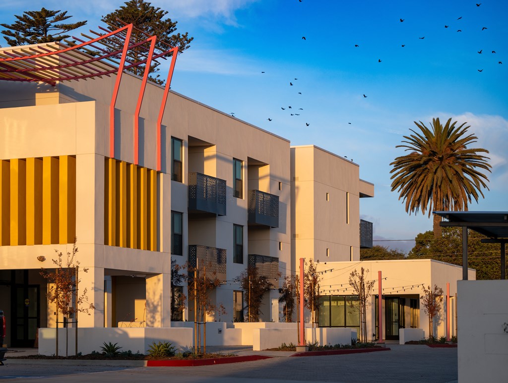 A modern building with a white facade and yellow accents.