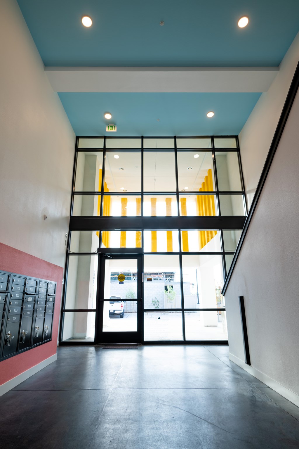 A hallway with a glass door and a staircase.