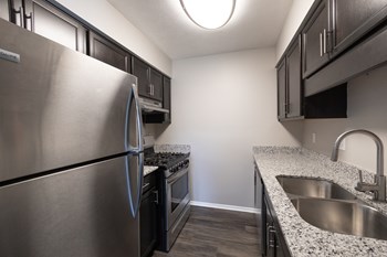 Kitchen with Stainless Steel Appliances in the Two Bedroom One Bath Apartment  at Woodbridge Apartments Bloomington - Photo Gallery 60