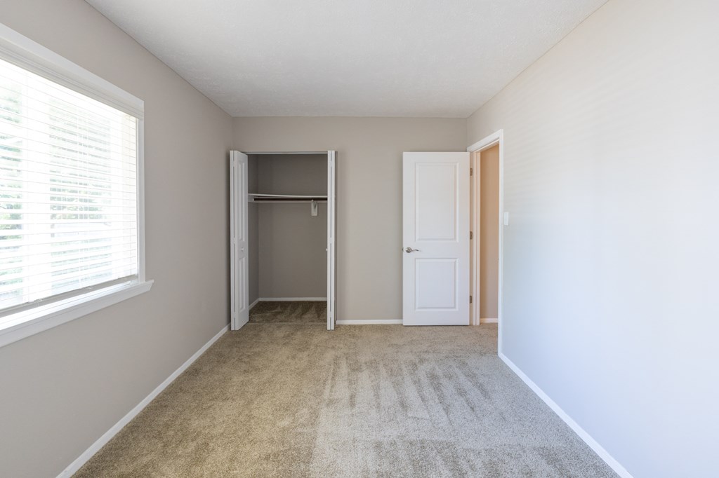Second Bedroom with a Closet and Large Windows in the Two Bedroom Townhome at Woodbridge Apartments Bloomington