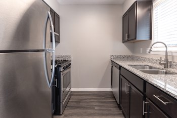 Kitchen with Stainless Steel Appliances in the Two Bedroom Townhome at Woodbridge Apartments Bloomington - Photo Gallery 48