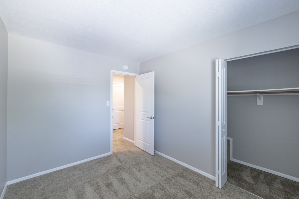 Second Bedroom with Ample Closet Space in the Three Bedroom Townhome at Woodbridge Apartments Bloomington