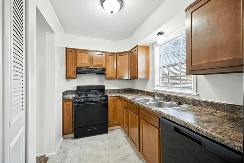 A kitchen with wooden cabinets and a black stove top oven.
