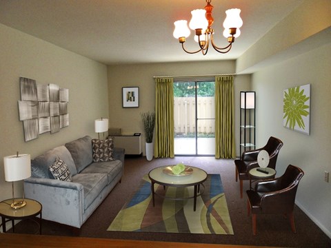 A living room with a grey couch, a coffee table, and a chandelier.