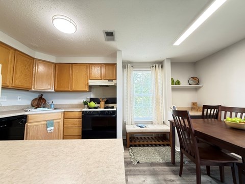 A kitchen with wooden cabinets and a dining table with chairs.
