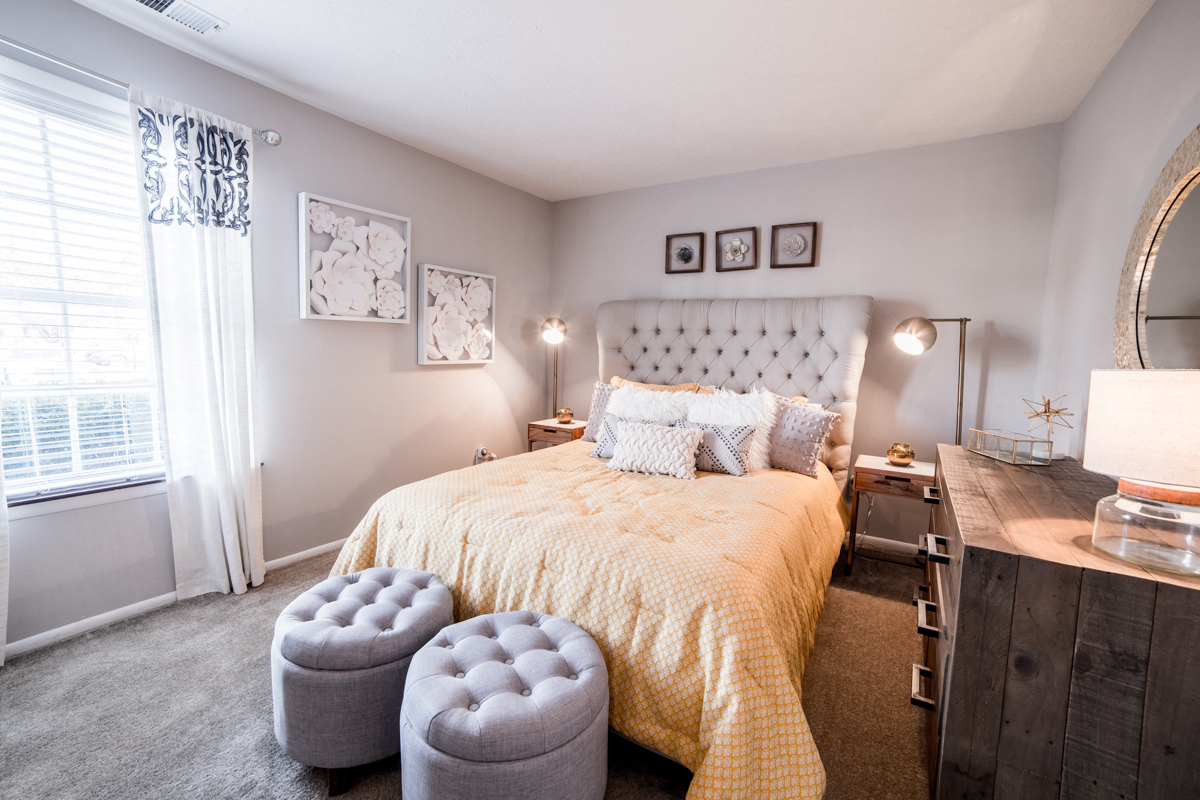 Bedroom with a window and neutral colored walls at Chelsea Village Apartments