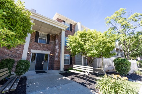 A brick building with a black door and a small porch.