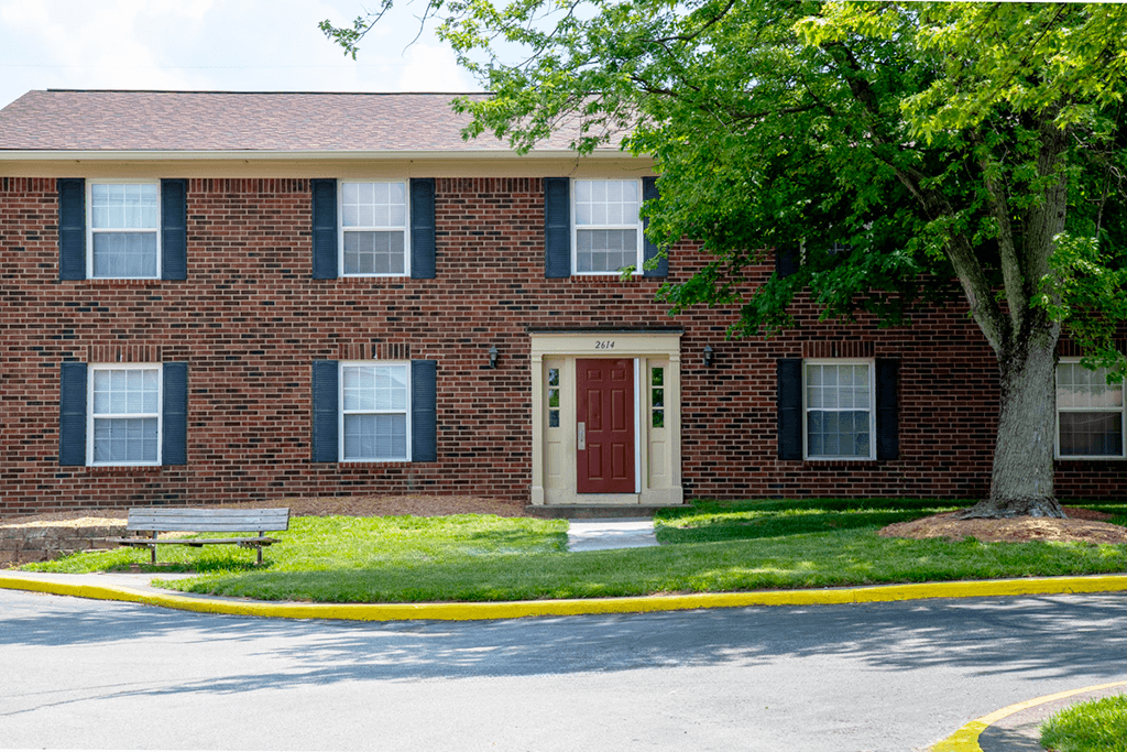 A red door is on the front of a brick building.