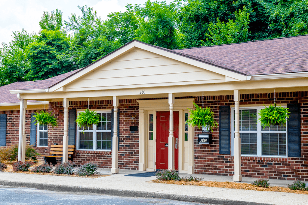 A house with a red door and a mailbox on the right side.