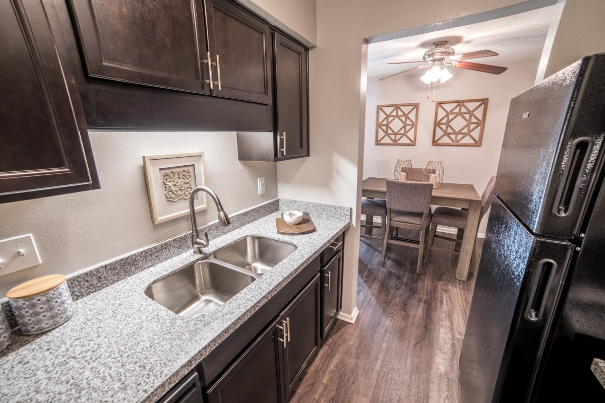 Renovated Kitchen with granite countertops and stainless-steel sink at Chelsea Village Apartments
