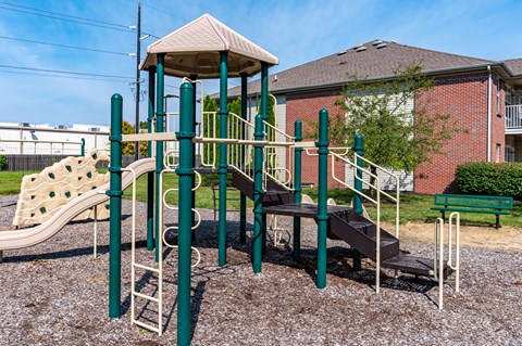 A playground with a green slide and a brown slide.