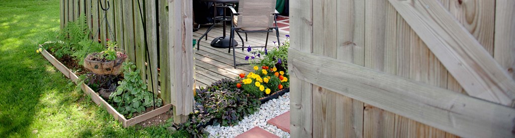 a view of a garden from the side of a fence