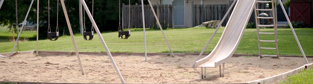 a playground with swings and sand and a ladder