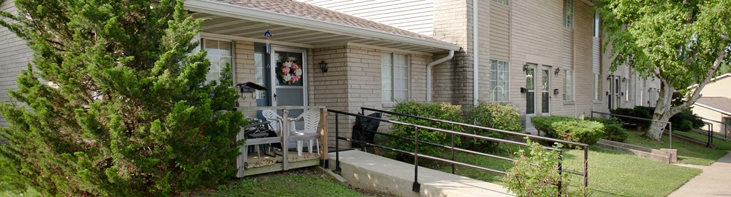 the front porch of a house with a rocking chair on it