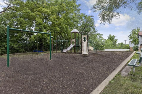 a playground with a slide and swings in a park