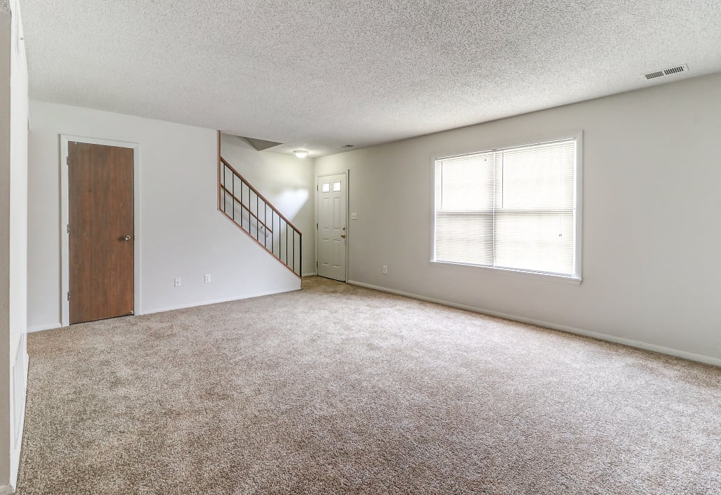 Townhome living room with access to the front door and stairs at Ashley Pointe Apartments