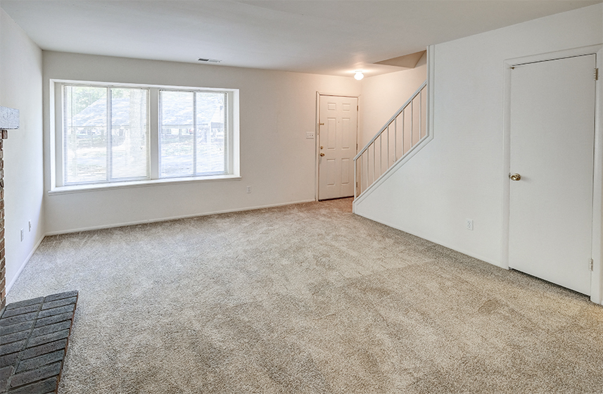 Townhome living room with windows and stairs to the next level at The Woods of Eagle Creek
