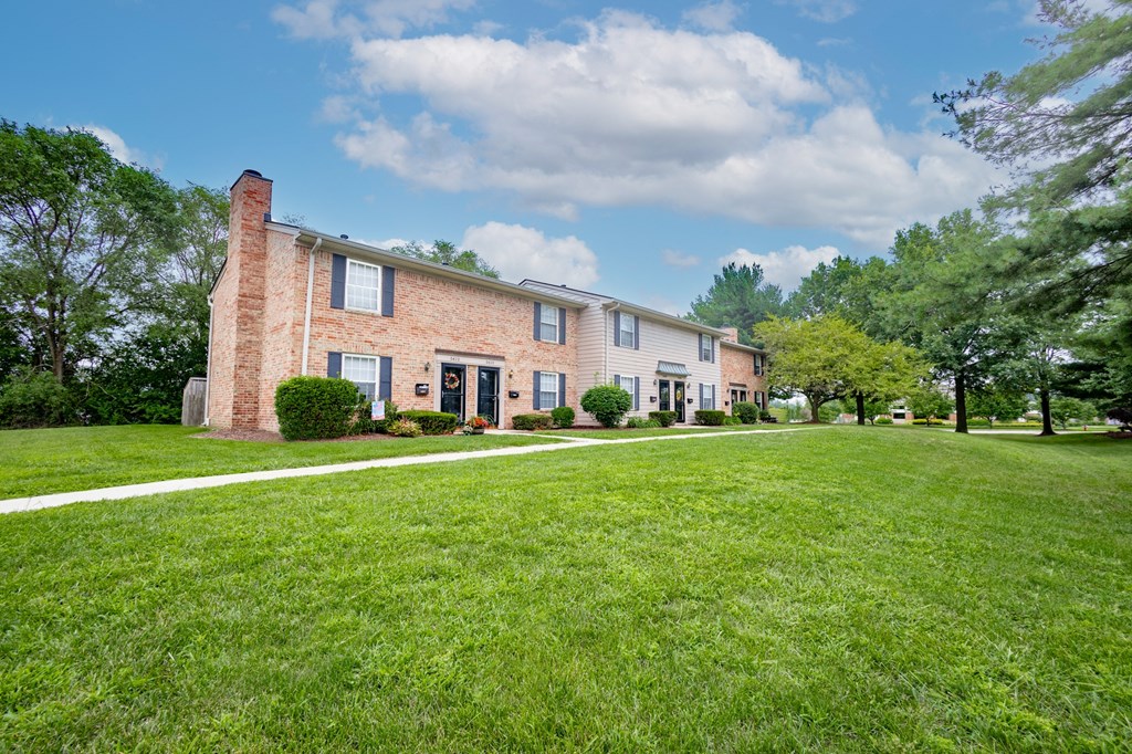 a large brick house with a lawn in front of it