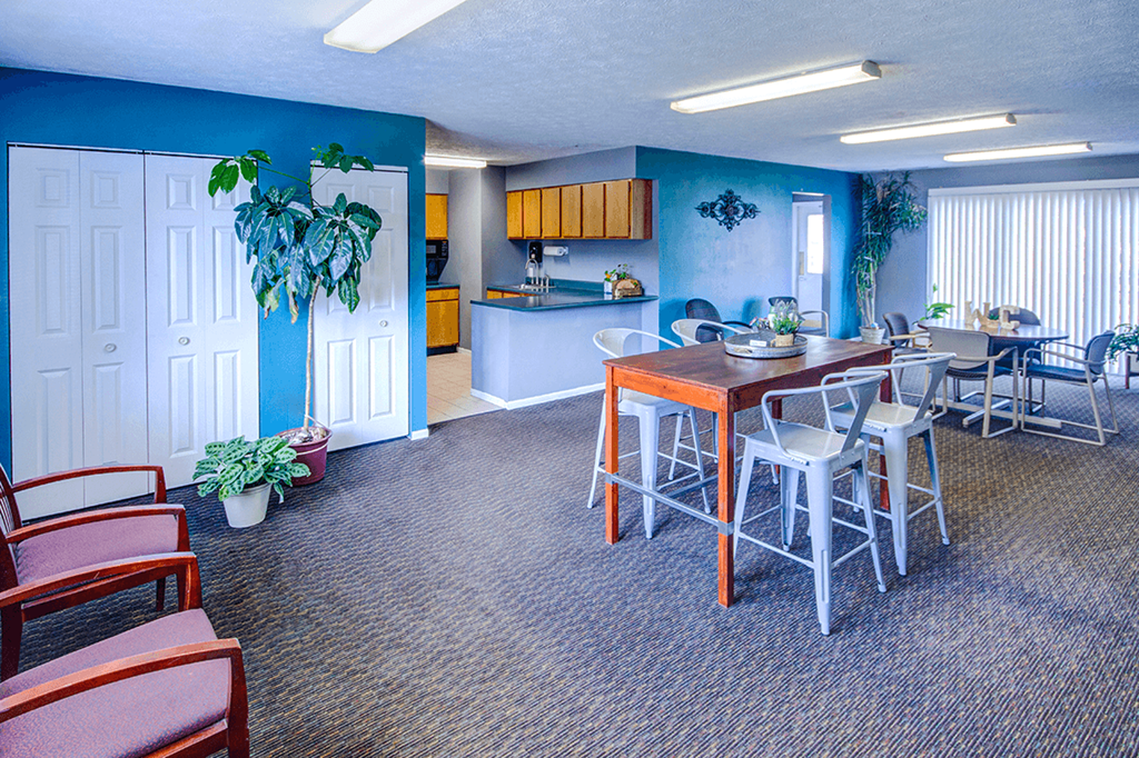 Clubhouse at Woodland Crossing, featuring a spacious communal area with seating, large windows, and a kitchen, ideal for social gatherings and events.