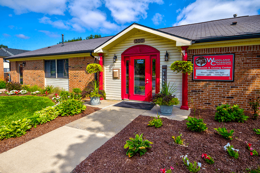 Exterior view of the leasing office and clubhouse at Woodland Crossing, showcasing landscaped surroundings and a welcoming entrance.