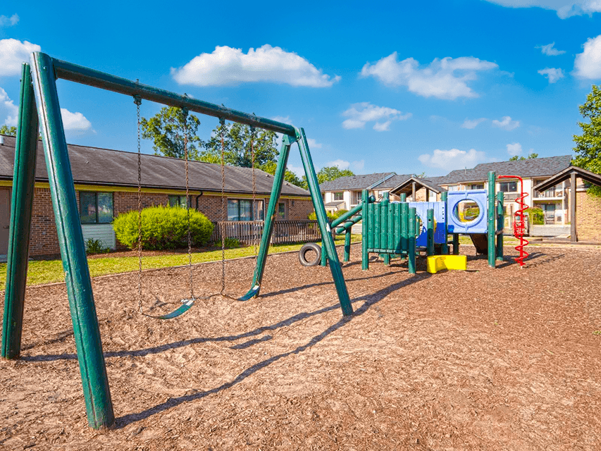 Playground at Woodland Crossing featuring swings, and climbing structures.