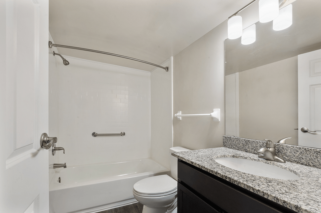 Bathroom with a sink, toilet, and bathtub in a 1-bed, 1-bath apartment at Carriage House Apartments, Kendallville.