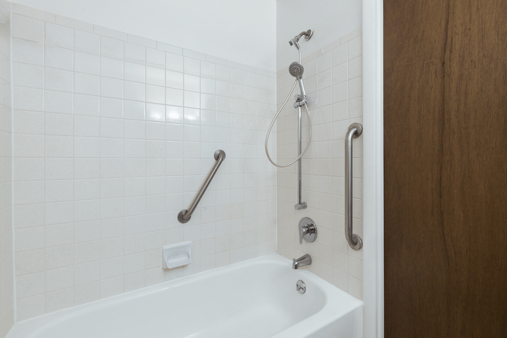 Bathroom with a tub head and hand held shower in a 1-bedroom, 1-bath senior apartment at Northwood Apartments in Franklin.