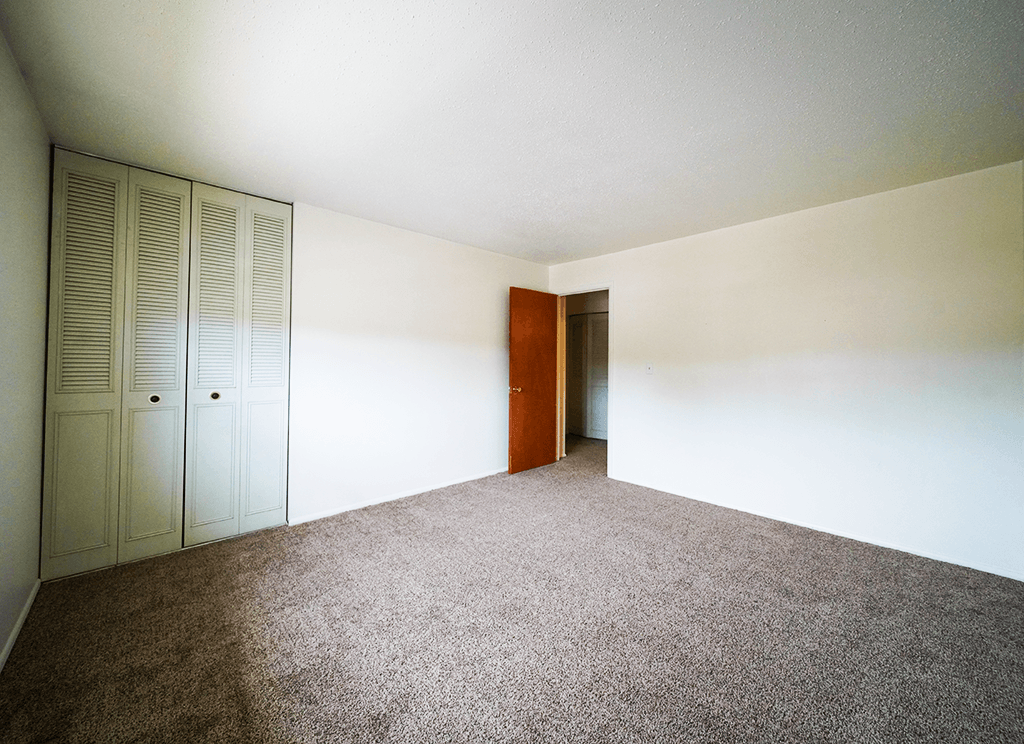 Bedroom with a closet in a 2-bedroom townhome at Rainbow Hills Apartments, featuring a spacious layout.