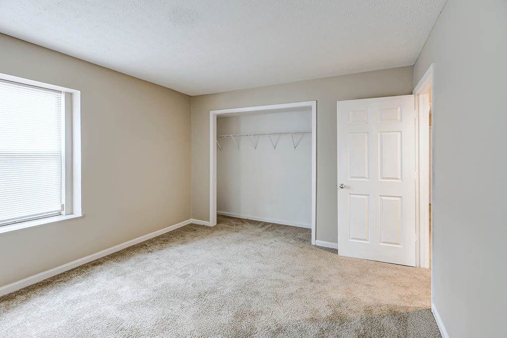 Bedroom with a closet in a 2-bedroom, 1-bath apartment at Hampton Place Apartments, offering storage and shelving.