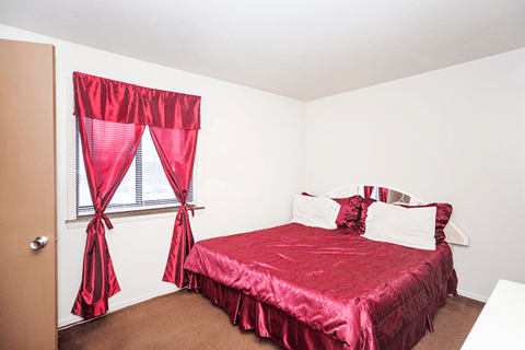 Bedroom at Henderson Court Apartments featuring a window.